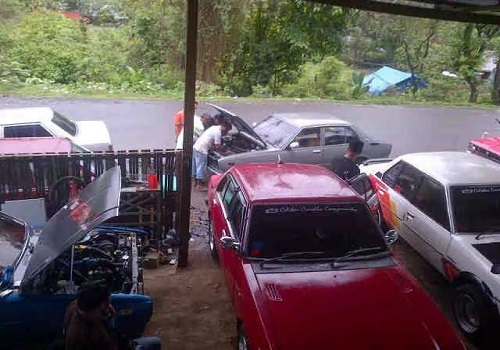 Sekumpulan mobil sedan Corolla yang terparkir di bengkel untuk diservice sebelum melakukan touring